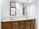 Spacious bathroom featuring double sink vanity with white countertop, wooden cabinets and framed mirrors at 448 Shorewood Ln, New Smyrna Beach, FL 32168