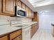 Kitchen featuring wooden cabinets, white appliances, and ample countertop space at 448 Shorewood Ln, New Smyrna Beach, FL 32168