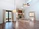 Spacious living room featuring a stone fireplace, hardwood floors, and high ceilings at 448 Shorewood Ln, New Smyrna Beach, FL 32168