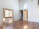 Light-filled living room boasts wood-look flooring, tall ceilings, and stairs to a second floor at 448 Shorewood Ln, New Smyrna Beach, FL 32168