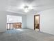 Spacious living room with a ceiling fan, gray carpet, and an open staircase at 448 Shorewood Ln, New Smyrna Beach, FL 32168