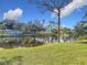 Picturesque view of a community pond with a fountain, surrounded by lush greenery and clear blue skies at 448 Shorewood Ln, New Smyrna Beach, FL 32168