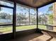 Screened porch with brick trim showcasing a view of the pond, fountain and lush landscaping at 448 Shorewood Ln, New Smyrna Beach, FL 32168