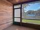 Screened porch with wood siding overlooking a peaceful pond, with an array of foliage at 448 Shorewood Ln, New Smyrna Beach, FL 32168