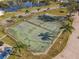 Aerial view of community tennis courts and sidewalks, surrounded by mature landscaping at 448 Shorewood Ln, New Smyrna Beach, FL 32168