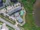 Aerial view of community showing the pool, parking, lush landscaping, and community's proximity to the water at 4860 S Atlantic Ave # 1030, New Smyrna Beach, FL 32169