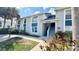 Exterior view of a condo building featuring a light gray facade, blue accents, and well-maintained landscaping at 4860 S Atlantic Ave # 1030, New Smyrna Beach, FL 32169