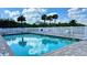 Community pool with lounge chairs and tables surrounded by lush green landscaping and palm trees at 4860 S Atlantic Ave # 1030, New Smyrna Beach, FL 32169