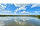 Scenic water view reflecting the sky with lush trees in the background and beautiful cloudscape at 4860 S Atlantic Ave # 1030, New Smyrna Beach, FL 32169