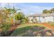 A tranquil backyard featuring lush greenery, a well-kept lawn, and thoughtful landscaping for added privacy at 601 N Peninsula Ave, New Smyrna Beach, FL 32169