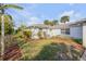 A serene backyard showcasing a well-maintained lawn, privacy landscaping, and a cozy outdoor space at 601 N Peninsula Ave, New Smyrna Beach, FL 32169