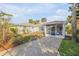 A serene backyard showcasing a well-maintained lawn, privacy landscaping, a screen porch, and a concrete driveway at 601 N Peninsula Ave, New Smyrna Beach, FL 32169