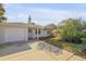 A well-maintained yard showcasing verdant landscaping, a concrete driveway, and a one-car garage at 601 N Peninsula Ave, New Smyrna Beach, FL 32169