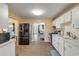 Kitchen featuring white cabinets, stainless steel appliances, with a connected dining and living area at 601 N Peninsula Ave, New Smyrna Beach, FL 32169