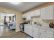 Functional kitchen featuring white cabinets and view to the connected living spaces at 601 N Peninsula Ave, New Smyrna Beach, FL 32169