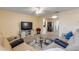 Inviting living room with a large TV, ceiling fan, and neutral-toned decor at 601 N Peninsula Ave, New Smyrna Beach, FL 32169