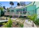 Charming backyard featuring a spacious wooden deck, well-maintained stone walkway, and lush tropical landscaping at 61 E Bayshore Dr, Port Orange, FL 32127