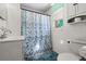 Cozy bathroom showcases a vanity, toilet, and bathtub with a charming floral-patterned shower curtain at 61 E Bayshore Dr, Port Orange, FL 32127