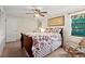 Well-lit bedroom with a ceiling fan, comfortable bed, tiled flooring, and a large window at 61 E Bayshore Dr, Port Orange, FL 32127