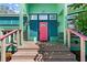 Inviting front entrance with a pink front door, flanked by sconces and shutters, and a small porch at 61 E Bayshore Dr, Port Orange, FL 32127