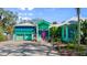 Unique home with bright turquoise exterior, two-car garage, and vibrant pink front door at 61 E Bayshore Dr, Port Orange, FL 32127