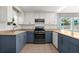 Open kitchen with stainless steel appliances, white and blue cabinets and neutral countertops at 61 E Bayshore Dr, Port Orange, FL 32127