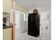 Efficient kitchen layout with modern refrigerator and convenient access to an adjacent half bathroom at 61 E Bayshore Dr, Port Orange, FL 32127
