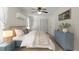 Cozy bedroom featuring a ceiling fan, blue dresser, and plush bed with striped linens at 61 E Bayshore Dr, Port Orange, FL 32127