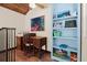 Bright office space with a wooden desk, built-in blue bookcase, and tiled flooring at 61 E Bayshore Dr, Port Orange, FL 32127