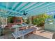 Covered patio area with ceiling fan, stone floor and dining table at 61 E Bayshore Dr, Port Orange, FL 32127