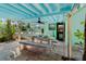 Covered patio area with ceiling fan, stone floor and outdoor access at 61 E Bayshore Dr, Port Orange, FL 32127