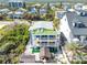 Stunning aerial view of the multi-story home features a rooftop deck, balconies, and a backyard gazebo with firepit at 6531 Turtlemound Rd, New Smyrna Beach, FL 32169