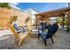 Backyard features gravel ground cover, yellow and blue Adirondack chairs and a fire pit under a gazebo at 6531 Turtlemound Rd, New Smyrna Beach, FL 32169