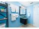 Cozy bathroom featuring a dark vanity, sink, toilet, and shelf near the mirror with towels at 6531 Turtlemound Rd, New Smyrna Beach, FL 32169