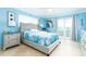 Light-filled bedroom features blue accents, tiled floors, slider to deck, and coastal decor at 6531 Turtlemound Rd, New Smyrna Beach, FL 32169