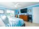 Bright bedroom featuring a king-size bed, ceiling fan, dresser, and access to a private balcony at 6531 Turtlemound Rd, New Smyrna Beach, FL 32169