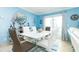 Stylish dining room with modern white table, comfortable seating, and serene blue walls at 6531 Turtlemound Rd, New Smyrna Beach, FL 32169