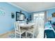 Dining room with a white table, blue accent wall, and seating for six at 6531 Turtlemound Rd, New Smyrna Beach, FL 32169