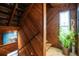 Unique wooden hallway with stairs leading to upper level and a decorative plant next to window at 6531 Turtlemound Rd, New Smyrna Beach, FL 32169