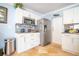 Bright kitchen features white cabinetry, stainless steel refrigerator, and decorative backsplash at 6531 Turtlemound Rd, New Smyrna Beach, FL 32169