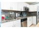 Well-equipped kitchen with white cabinets, granite countertops, and stainless steel appliances at 6531 Turtlemound Rd, New Smyrna Beach, FL 32169