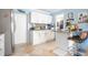 Modern kitchen with white cabinets, stainless steel appliances, and adjacent countertop bar with stool seating at 6531 Turtlemound Rd, New Smyrna Beach, FL 32169