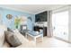 Cozy living room with white sofa, seaside accents, and sliding glass doors to a private balcony at 6531 Turtlemound Rd, New Smyrna Beach, FL 32169