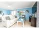 Bright living room featuring a comfortable white sofa, nautical décor, and natural light at 6531 Turtlemound Rd, New Smyrna Beach, FL 32169