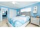 Serene main bedroom with a plush bed, soft blue accents, and an en-suite bathroom at 6531 Turtlemound Rd, New Smyrna Beach, FL 32169