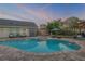 Backyard pool and spa with an umbrella shaded lounge area, offering a comfortable outdoor living space at 701 Kristina Ct, Port Orange, FL 32127