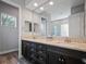 Bathroom featuring double vanity with granite counters, dark cabinetry, and a large mirror at 743 Aldenwood Trl, New Smyrna Beach, FL 32168