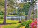 Waterfront backyard with lush landscaping and mature trees casting a tranquil view across the water at 751 Pine Shores Cir, New Smyrna Beach, FL 32168