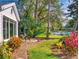 Waterfront backyard with lush landscaping and mature trees casting a tranquil view across the water at 751 Pine Shores Cir, New Smyrna Beach, FL 32168