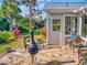Cozy backyard with a stone patio, lush greenery, and comfortable outdoor seating at 751 Pine Shores Cir, New Smyrna Beach, FL 32168